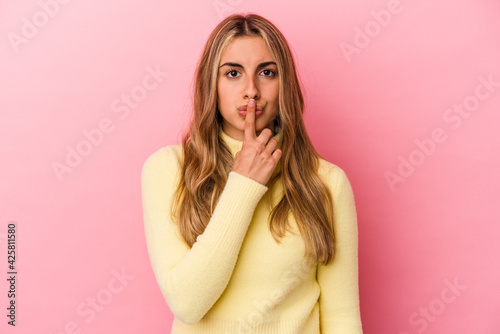 Young blonde caucasian woman isolated on pink background thinking and looking up, being reflective, contemplating, having a fantasy.