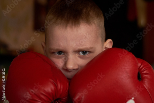 The boy closes with boxing gloves.