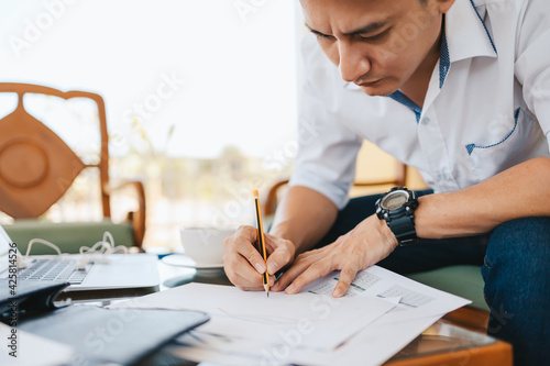 Administrator businessman making report, calculating balance. Business analyzing income charts, graphs and data on the table.