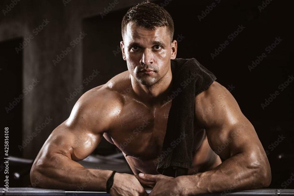 Fitness in gym, sport and healthy lifestyle concept. Handsome athletic man with naked torso on workout. Bodybuilder male model resting after hard training Fitness in gym, sport and healthy lifestyle concept. Handsome athletic man with naked torso on workout. Bodybuilder male model resting after hard training