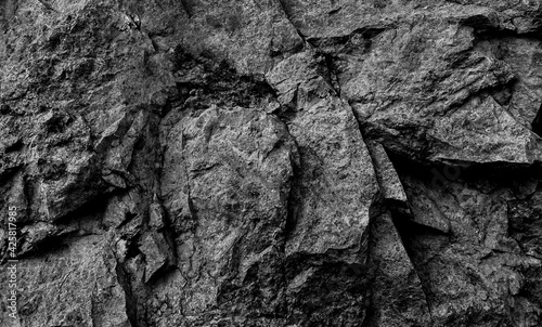 The texture of the stone is black.  Close-up of the rough texture of a large stone.  Stone surface for natural background.  Close-up of blurred stone background texture