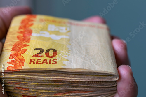 hand holding bundle of Brazilian money banknotes. photo