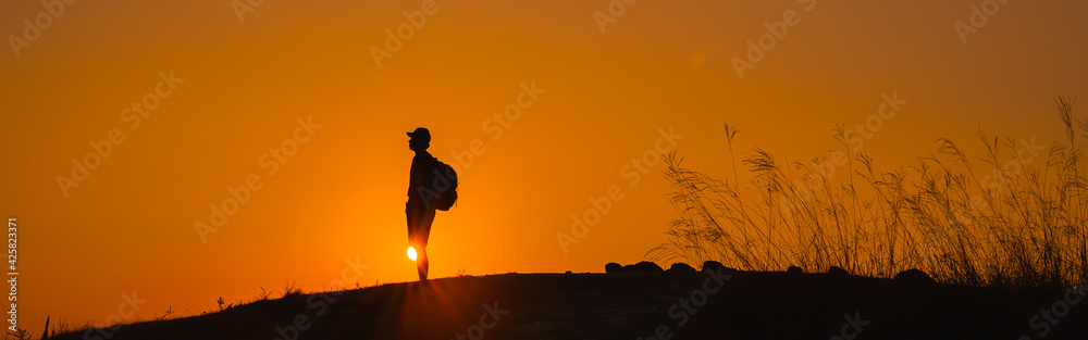 web banner adventure travel from silhouette man hiking and stand on top of the mountain in summer season