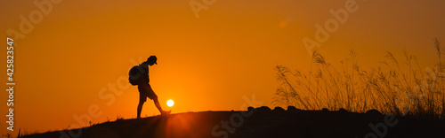 web banner adventure travel from silhouette man hiking and stand on top of the mountain in summer season