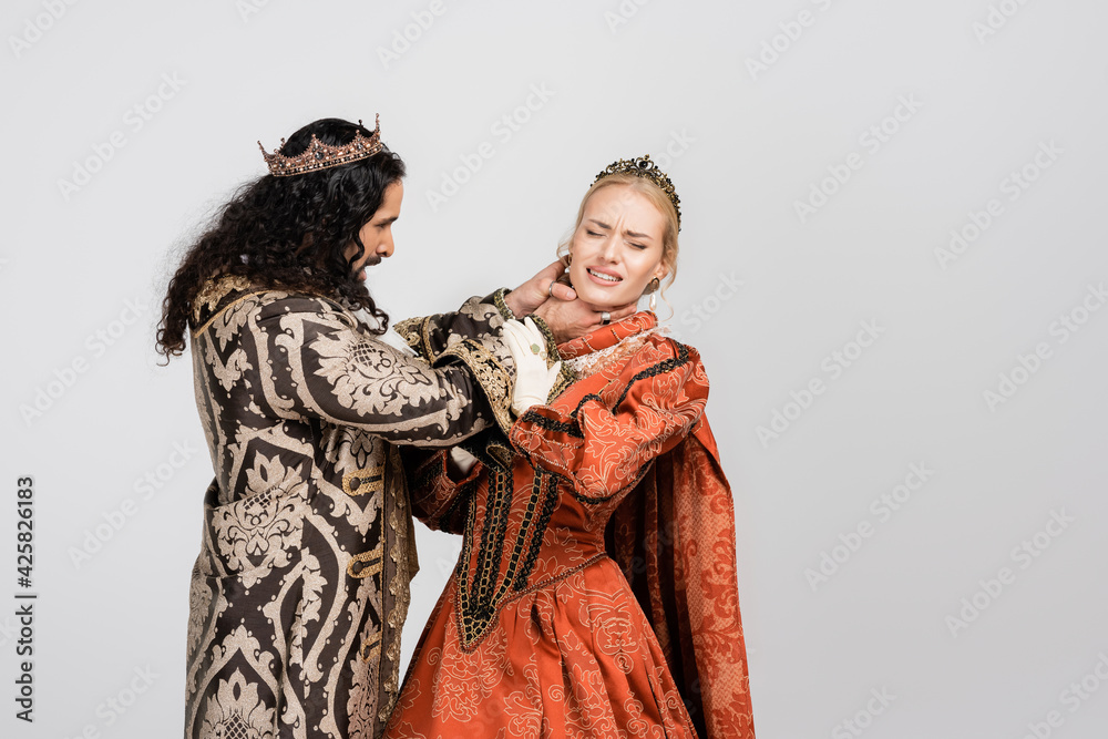 hispanic king in medieval clothing choking queen in crown on white
