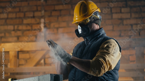 Male builder cleaning nose during work photo