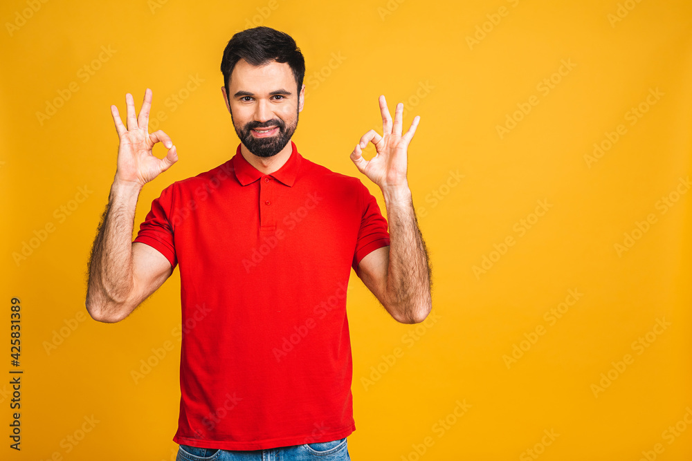 Happy handsome bearded man showing ok sign. Isolated over yellow background.