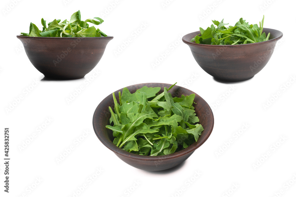 Fresh leaves of arugula in ceramic brown bowl isolated. Fresh leaves of arugula in ceramic brown bowl isolated.
