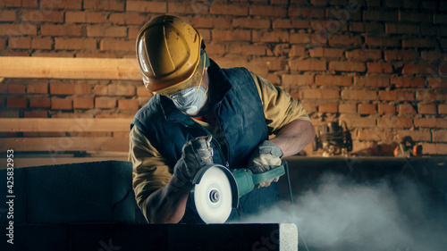 Photos Male builder in respirator cutting wall
