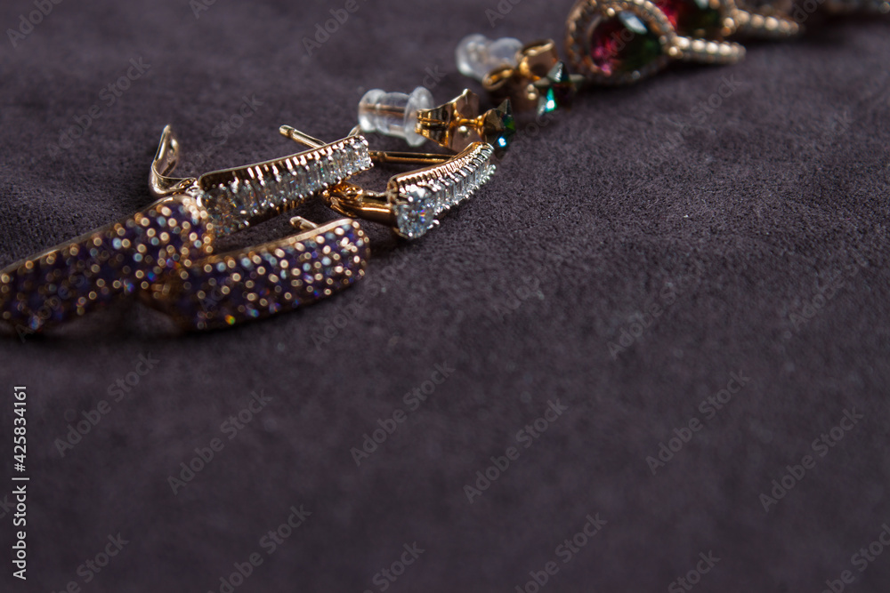 Close up isolated group gold and silver precious jewellery pieces on wood table selective focus on center of yellow brooch in front Close up isolated group gold and silver precious jewellery pieces on wood table selective focus on center of yellow brooch in front