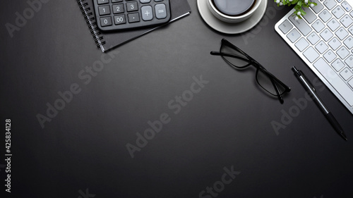 Top view of the black workspace. with equipment placed on the table at the office.