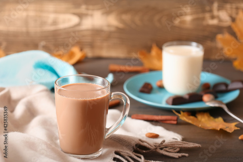 Cup of cocoa with straw on a dark wooden background