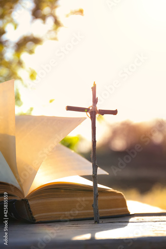 The Bible on the background of the cross and life-giving light