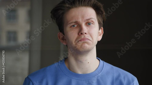 Caucasian guy millennial sad student young man isolated indoors at home looking at camera waving nods head says yes expressing consent support approval, portrait. Close-up male emotional face agrees