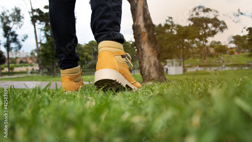  man with yellow boot walking in a park