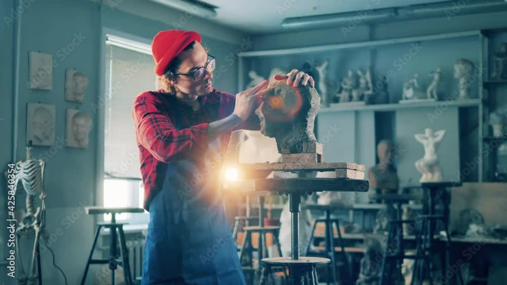 Male artist is working with a clay sculpture in the studio. Art concept, artist work in design studio. Male artist is working with a clay sculpture in the studio. Art concept, artist work in design studio.