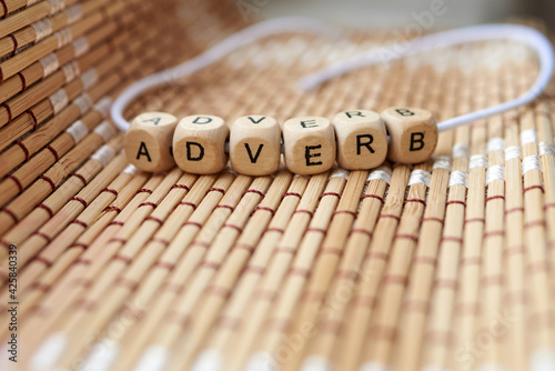 Word adverb lined with wooden cubes photo