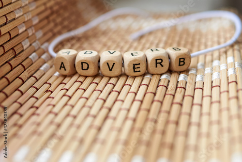 Word adverb lined with wooden cubes