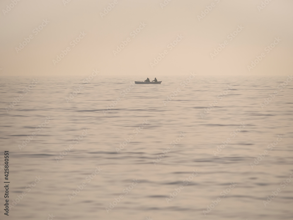 Vintage picture with a small fishing boat on the sea. Lonely boat in the middle of the Black sea