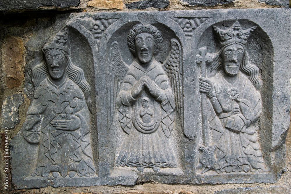detail of a stone carving of three religious figures
