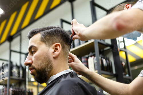 Barbershop. Master hairdresser makes hair and cuts beard