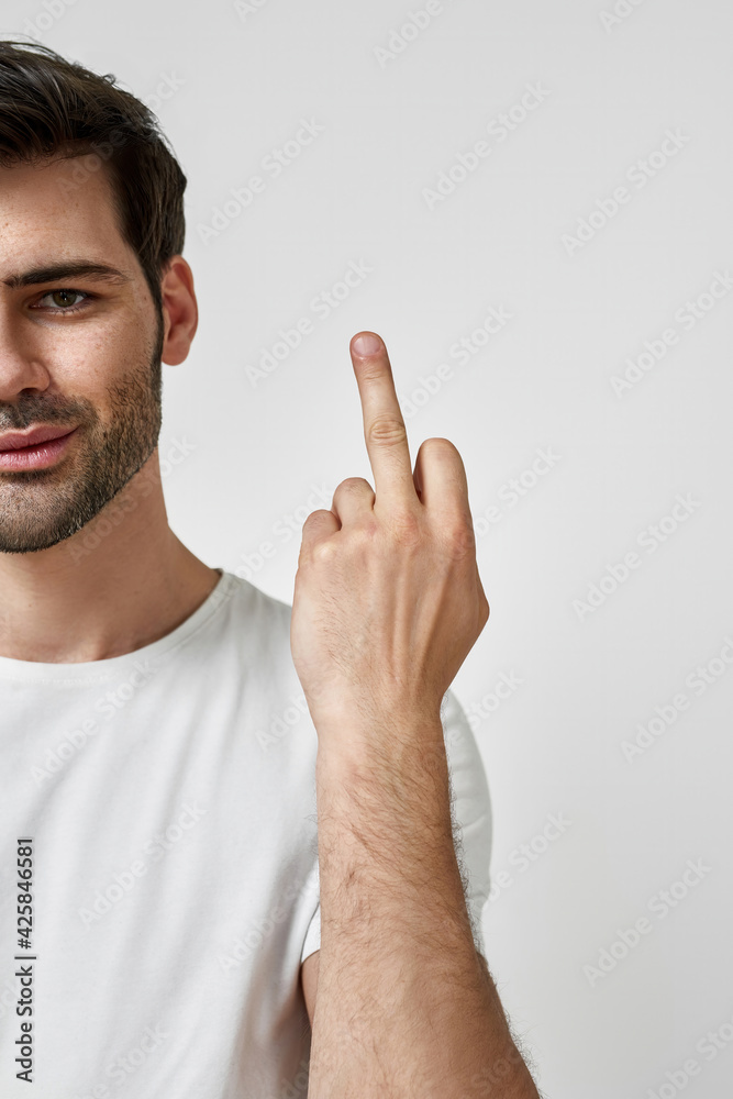 Young man wearing t-shirt showing middle finger Young man wearing t-shirt showing middle finger