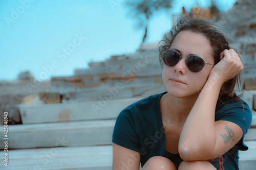 young woman sitting in historical place immersed in thought photo