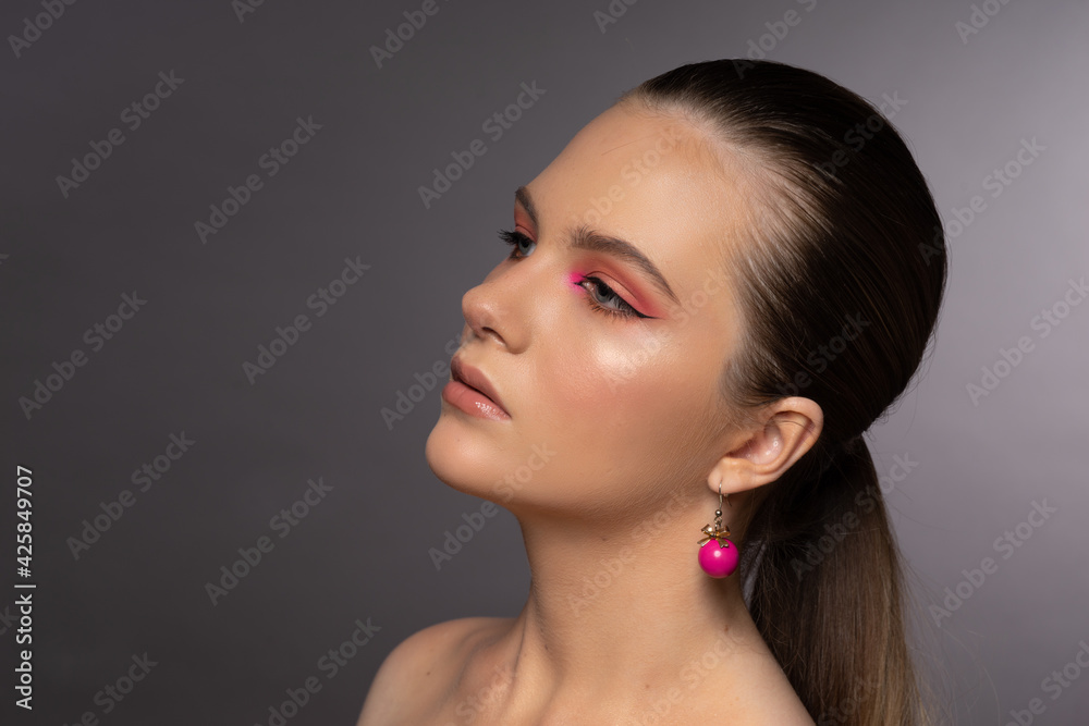 Naklejka premium Lovely woman, round pink earrings and beautiful professional makeup