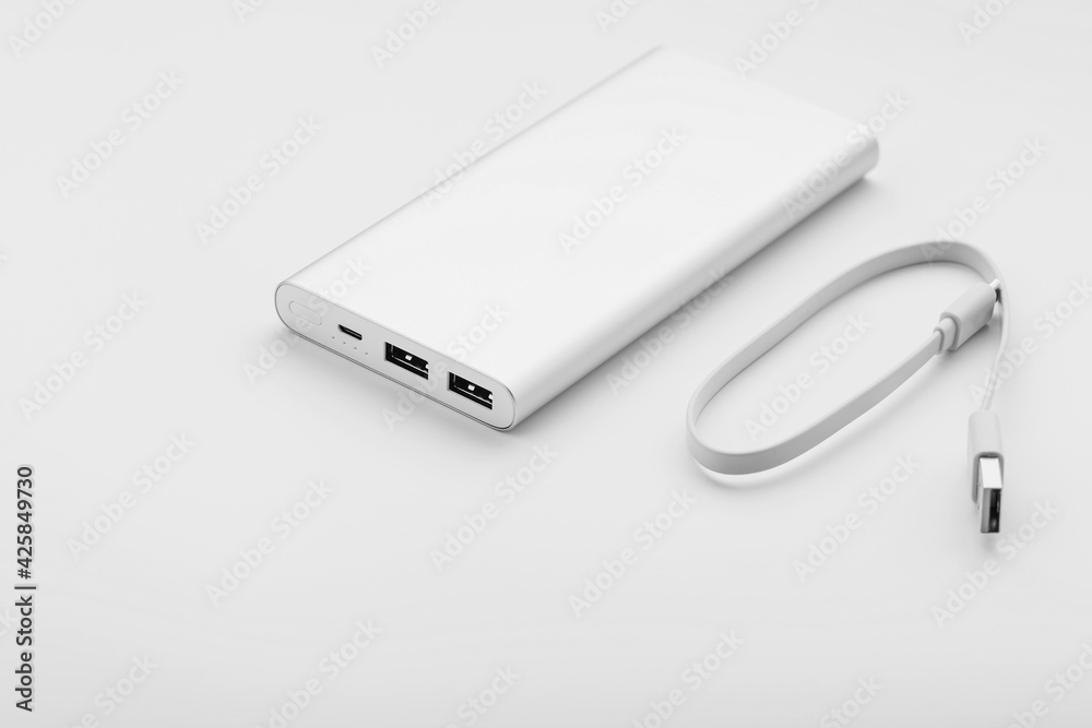 Powerbank for charging mobile devices with cable, on a white background. Powerbank for charging mobile devices with cable, on a white background.