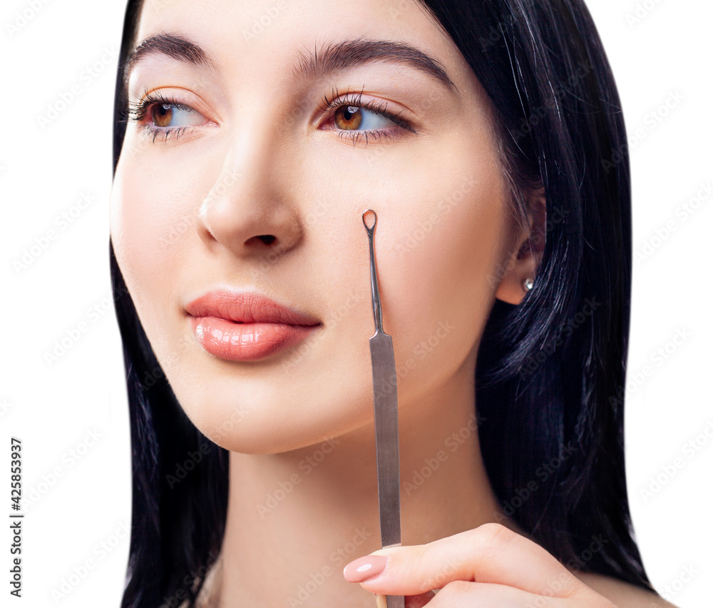 Brunette woman with cosmetics spoon for blackheads.