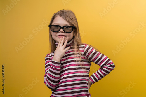 Children's cinema concept. White girl in 3D glasses with different emotions on a yellow background.