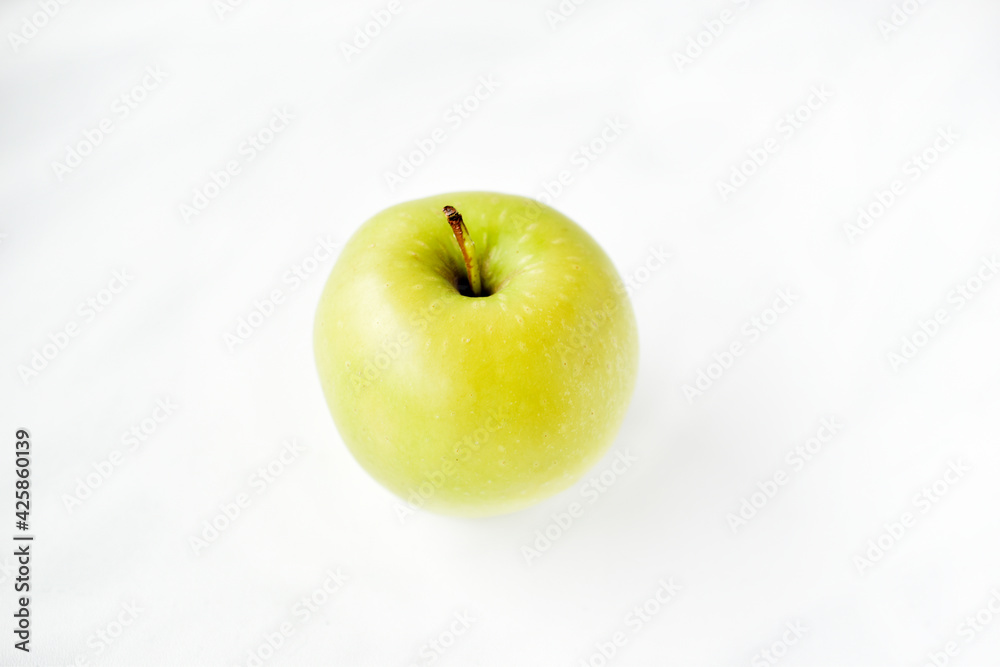 A bright green apple on a white background A bright green apple on a white background