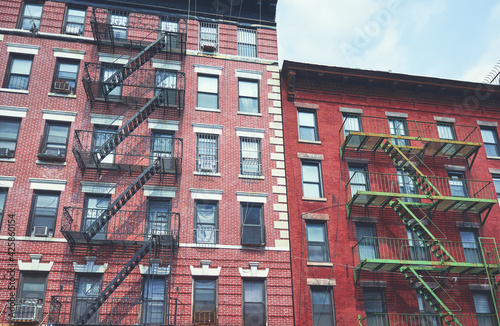Old brick buildings with fire escapes, color toning applied, New York City, USA.