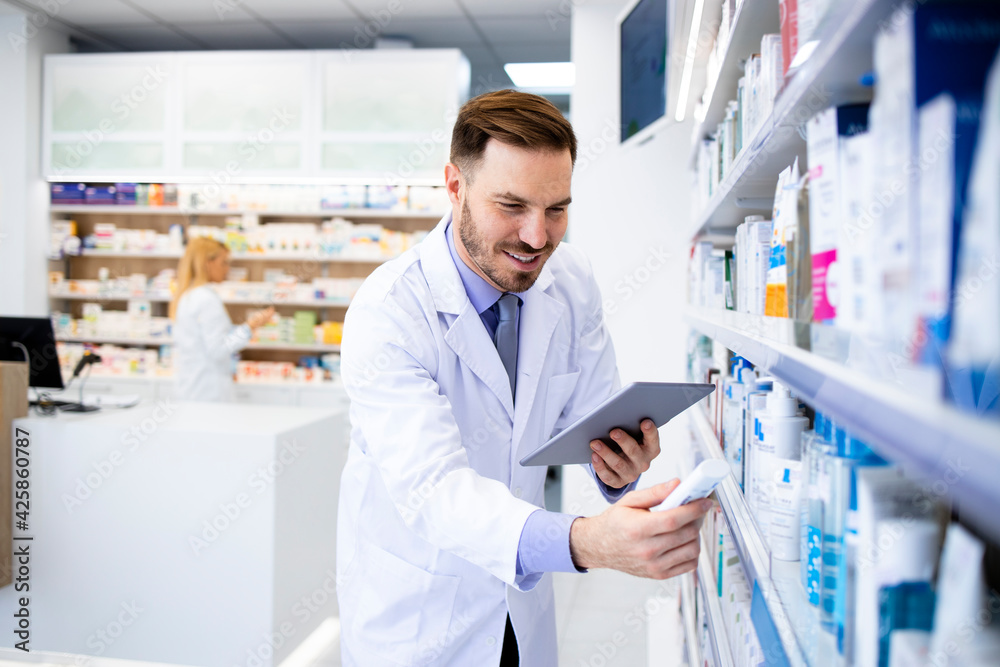 Pharmacist working in drug store and holding medicine.