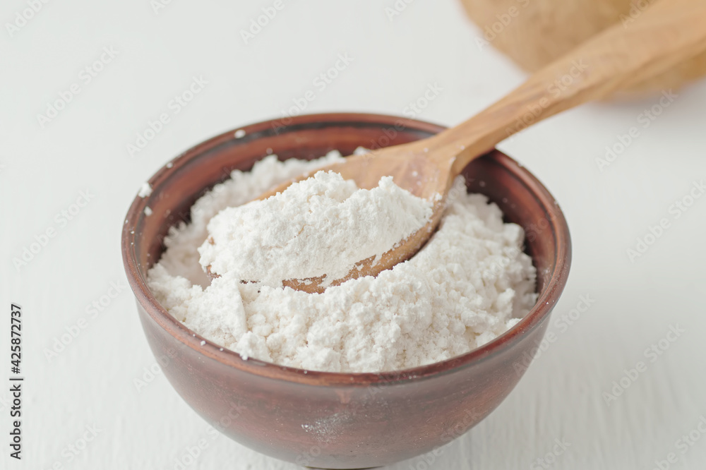 Coconut flour in a wooden spoon. Healthy foods.
