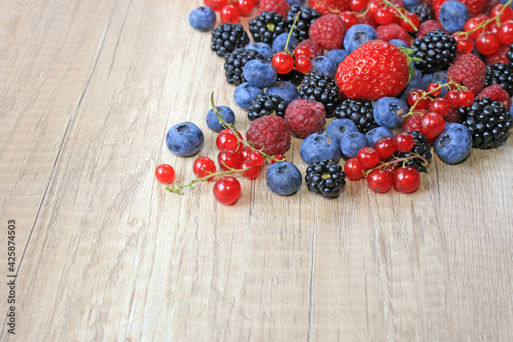 Fresh berries on wooden background, strawberry, blueberry, raspberry, blackberry and red currant Fresh berries on wooden background, strawberry, blueberry, raspberry, blackberry and red currant