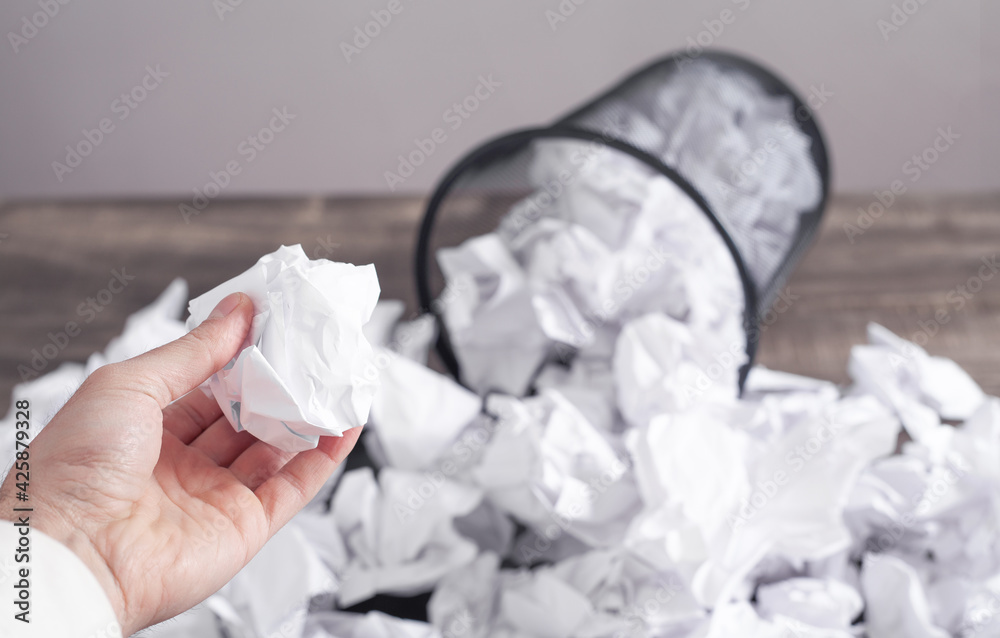 Man throwing crumpled paper into trash can. Stock 写真 Adobe Stock