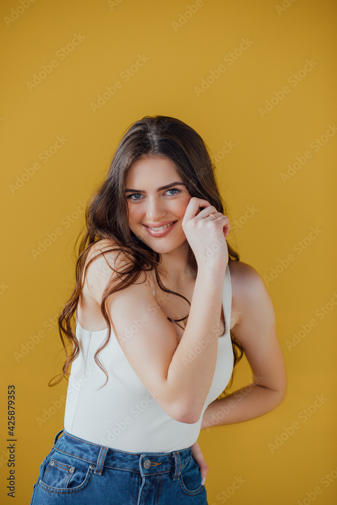 Image of excited screaming young woman standing isolated over yellow background. Looking camera.