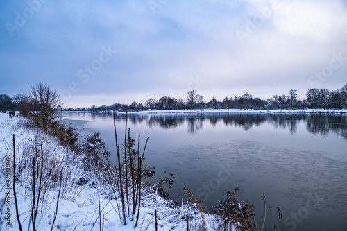 beautiful  almost frozen river called werdersee at cold white winter with snow in bremen