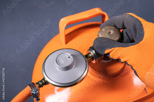 Unscrewing the valve in the propane-butane gas cylinder. Installation work on the gas installation.