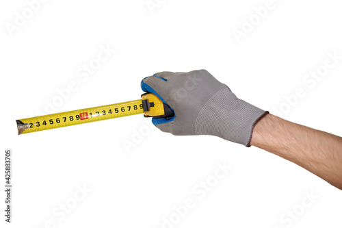 A man's gloved hand holds a tape measure a centimeter © millenius