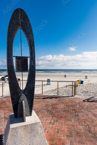 Surfboard sculpture on a red brick deck near beach entrance to New Smyrna Beach, Florida, USA.