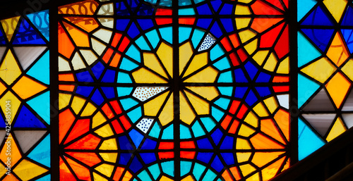 Colorful stained glass window. Bright geometric shapes. Beautiful ornament. © glazunoff