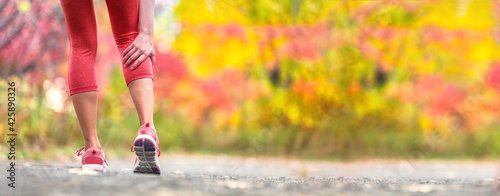 Foto Sport injury runner woman in pain holding back leg calf muscle hurting from cramp during trail run outdoor exercise