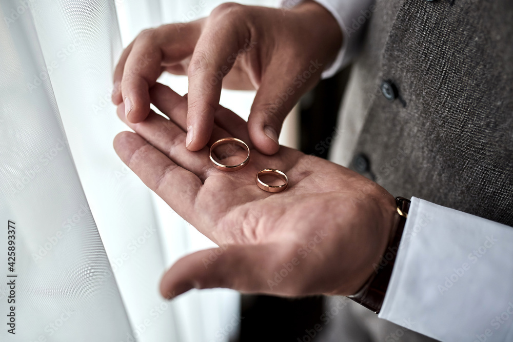 man holding wedding rings, groom getting ready in the morning before ceremony man holding wedding rings, groom getting ready in the morning before ceremony