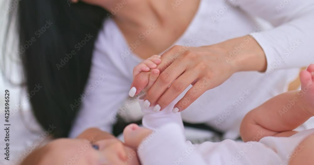 Close-up, the baby firmly holds his mother's finger by the hand. Legs and arms of the baby, mom holds the baby's handle and looks at him affectionately. 4k, ProRes Close-up, the baby firmly holds his mother's finger by the hand. Legs and arms of the baby, mom holds the baby's handle and looks at him affectionately. 4k, ProRes
