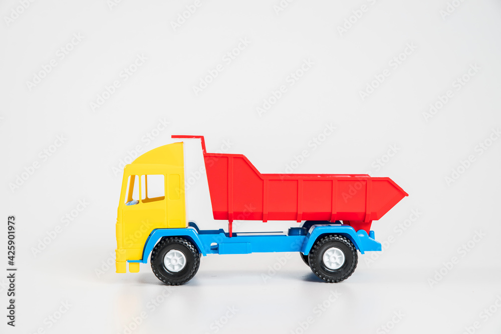 Children's toy plastic car isolated on white background. Multicolored truck.