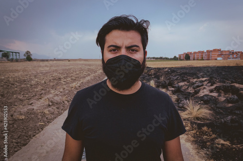 Hombre mexicano joven con cubrebocas en la pandemia covid-19 photo