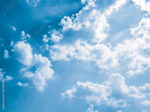 background of Summer sky of fluffy clouds, sun shining and moving clouds with copy space.