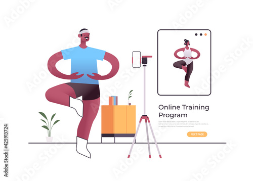 male dancer doing dancing exercises while watching online video training program with african american dance teacher
